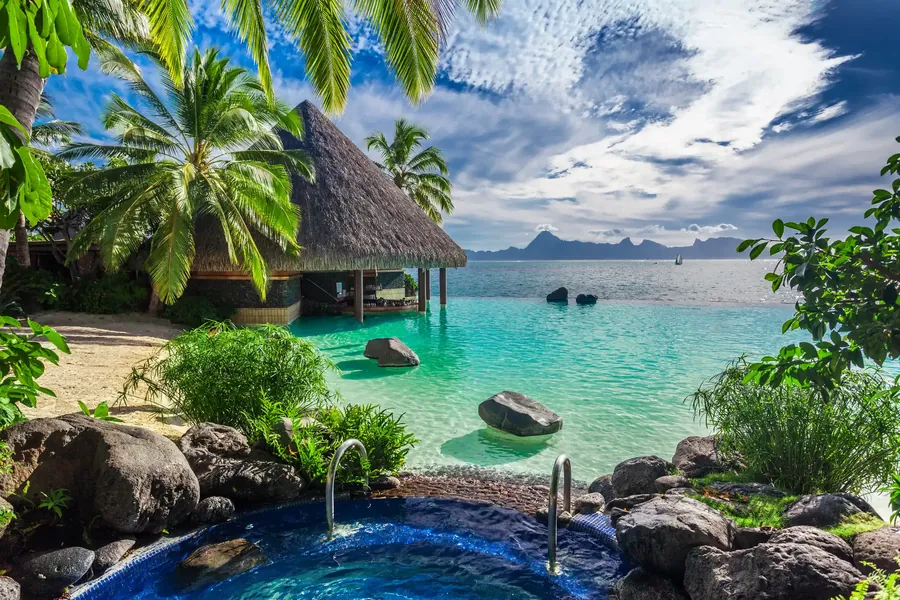 An infinity pool and jacuzzi above a tropical forest canopy