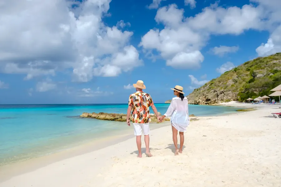 Playa Porto Mari in Curaçao with palms, white sand and calm blue water