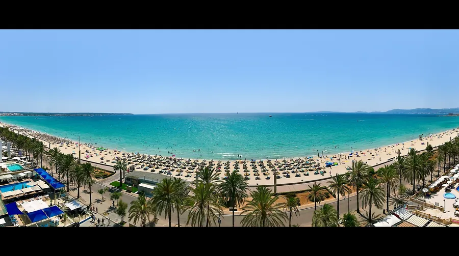 Playa de Palma from above, a long sandy beach with a palm-lined promenade