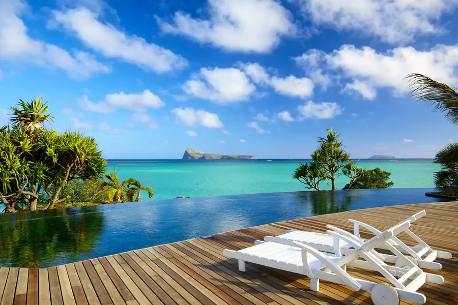 A pool deck under palms facing the lagoon in Mauritius