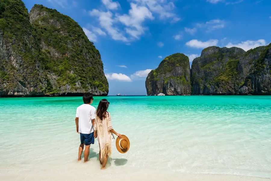 A couple on a white beach between limestone cliffs