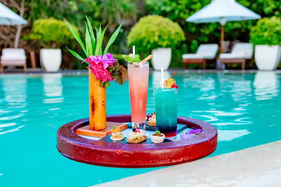 Cocktails on a floating tray in a tropical pool