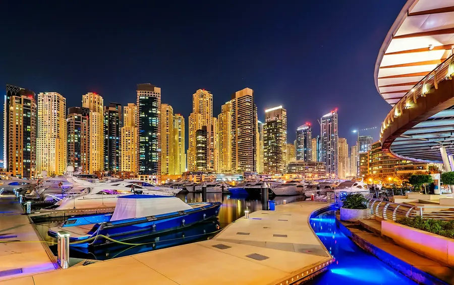 Dubai Marina at night with lit skyscrapers and yachts