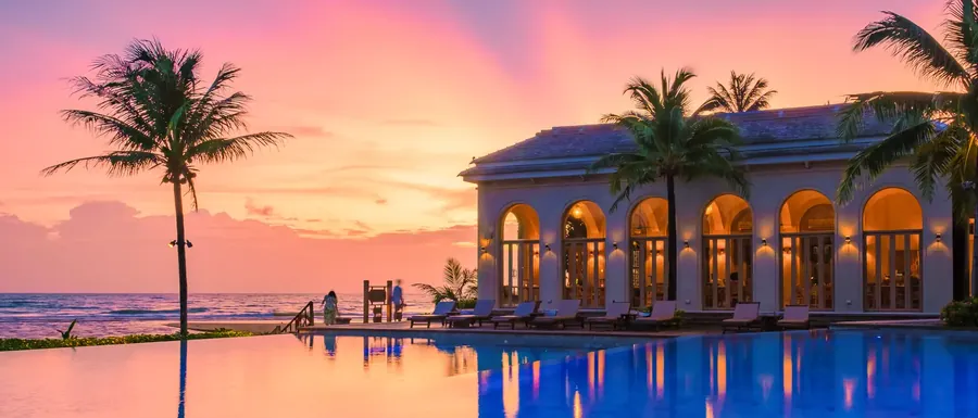 A resort pool at sunset on a tropical island